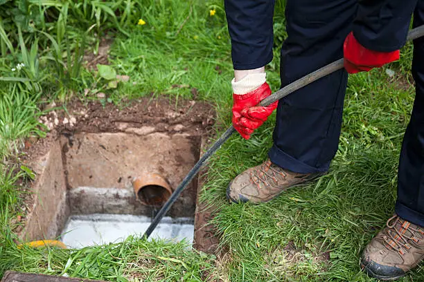 Drain cleaning technician inspecting a backed-up bathroom line inside a Pensacola - FL property